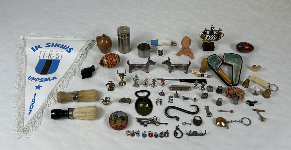 Låda diverse, bla miniatyrfigurer och silverhängen.
