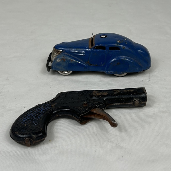 Plåtleksaksbil, Schuco, samt leksakspistol, 1900-talets mitt.