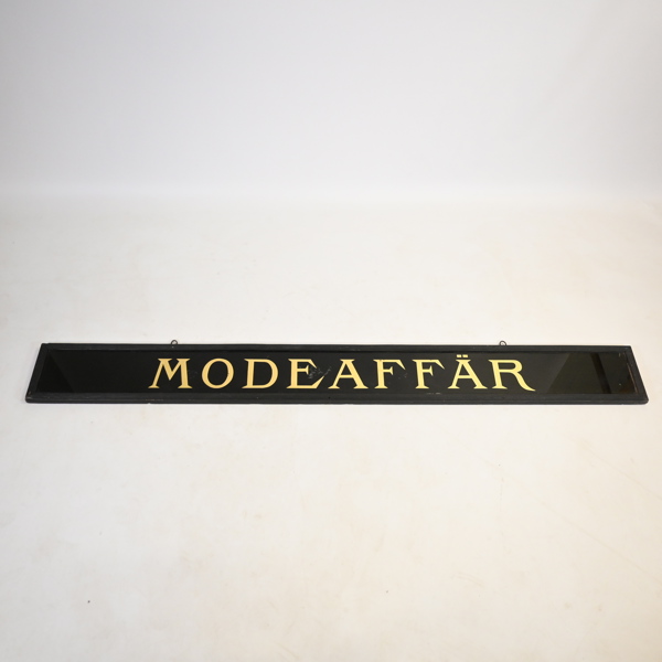 Skylt, "Modeaffär", 1900-tal. 