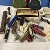 Diverse mynt, sedlar, armbandsur, fickknivar och munspel.