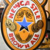 Reklamskylt, "Newcastle Brown Ale", omkring år 2000-tal.