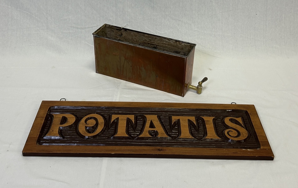 Potatisskylt i trä och vattenbehållare i koppar